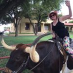 Laura Donefer in texas riding a long horn